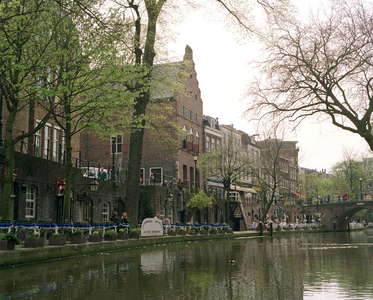 810097 Gezicht op de Oudegracht en werf te Utrecht met op de achtergrond de Jansbrug en links o.a. het huis Drakenburg ...